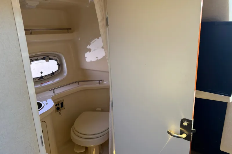 Slide: The Image of Interior view of 2013 Sea Ray Sundancer 280 bathroom with toilet and porthole window. - 38