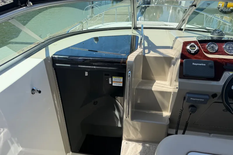 Slide: The Image of 2013 Sea Ray Sundancer 280 cockpit with Raymarine electronics and sleek dashboard design. - 20