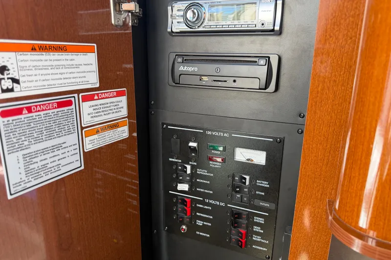 Slide: The Image of Control panel of a 2013 Sea Ray Sundancer 280 boat with warning labels and stereo system. - 40