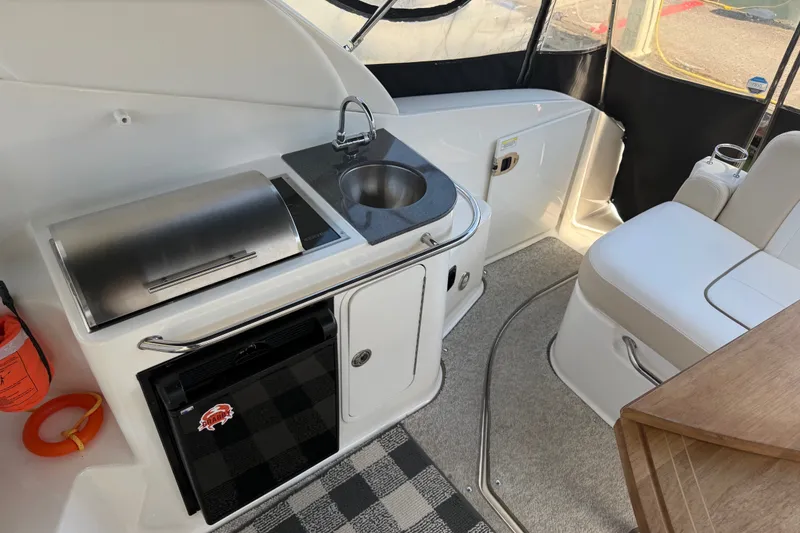 Slide: The Image of Interior of 2013 Sea Ray Sundancer 280 with kitchenette and seating area. - 11