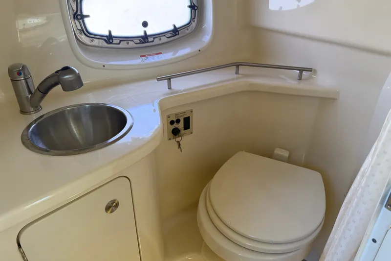 Slide: The Image of 2013 Sea Ray Sundancer 280 bathroom with sink, toilet, and porthole window. - 39