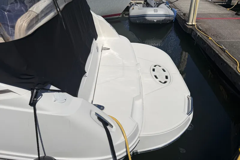 Slide: The Image of 2013 Sea Ray Sundancer 280 docked, featuring a covered seating area and swim platform. - 46