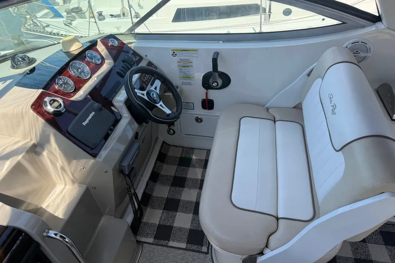 Slide: The Image of 2013 Sea Ray Sundancer 280 helm with steering wheel, gauges, and cushioned seating. - 14