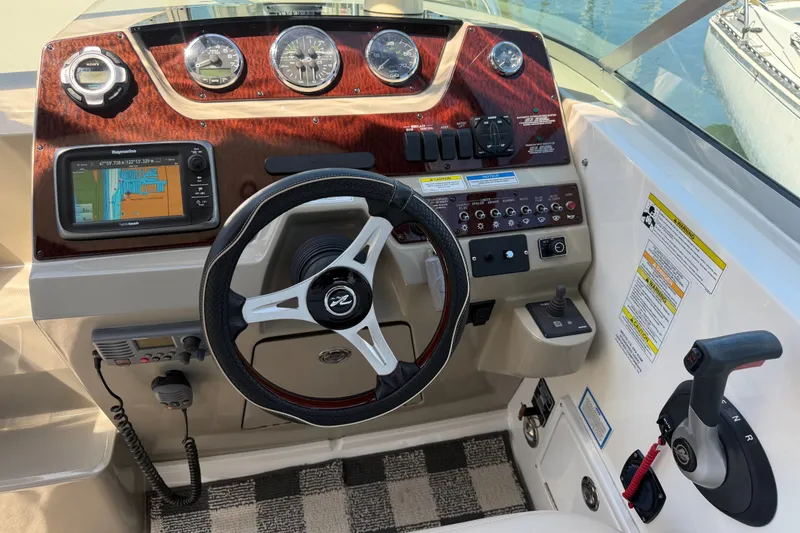 Slide: The Image of Dashboard of 2013 Sea Ray Sundancer 280 with steering wheel and navigation controls. - 15