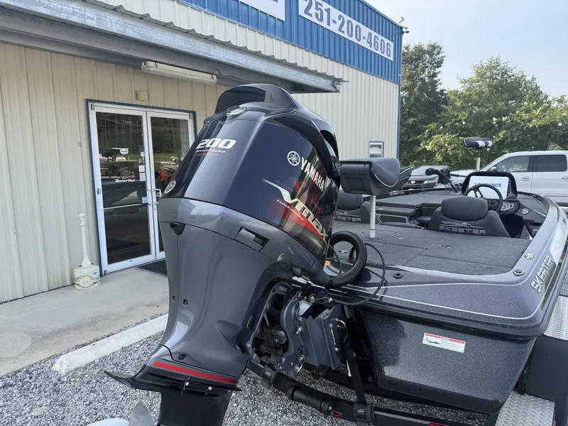 Slide: The Image of A 2018 Skeeter ZX200 boat with a Yamaha 200 outboard motor, parked in front of a building. - 6