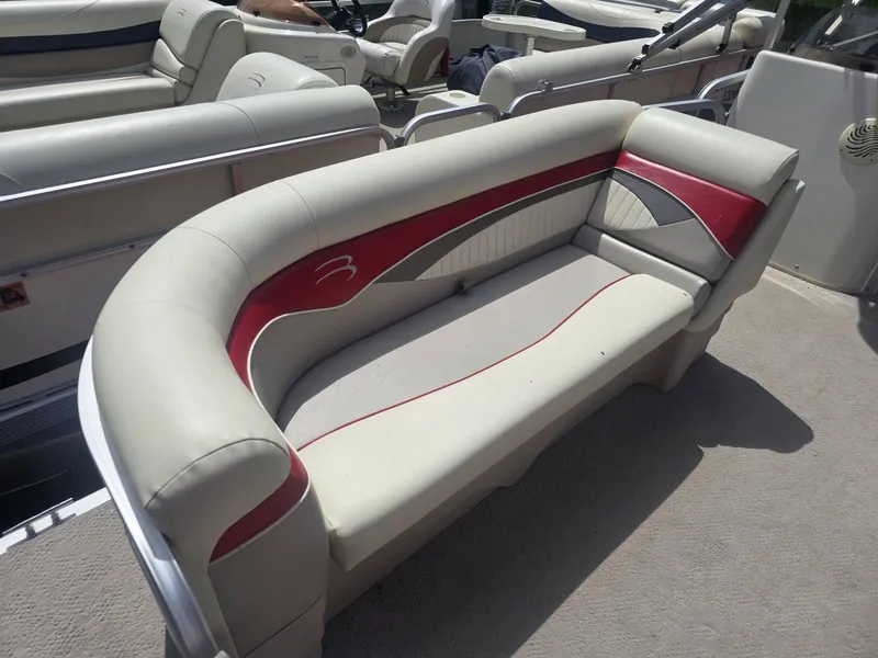 Slide: The Image of A sleek, cream-colored seating sofa with red accents on a Bennington 2275SL pontoon boat. - 3