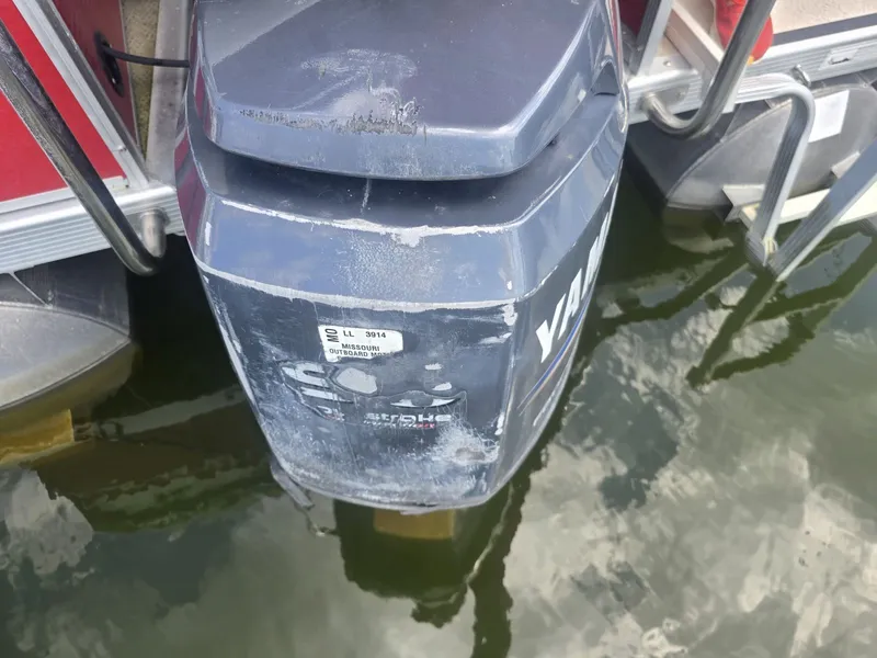Slide: The Image of An outboard motor on a boat, partially submerged in water, with a red boat hull in the background. - 11