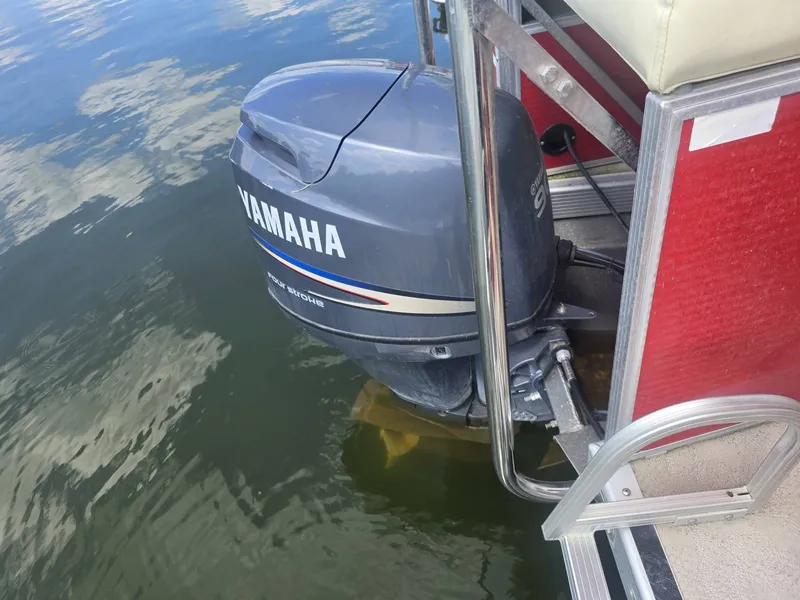 Slide: The Image of A Yamaha outboard motor is attached to a red Bennington pontoon boat floating on the water. - 10