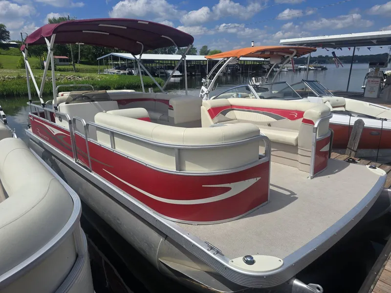 The Image of A red 2009 Bennington 2275SL pontoon boat docked on a sunny day. - 1