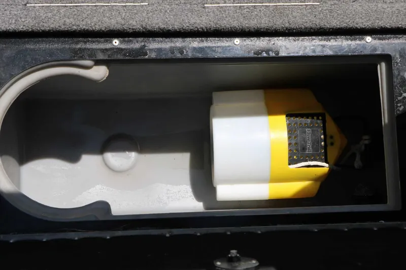 Slide: The Image of A storage compartment in the boat with a yellow and white item inside. - 42