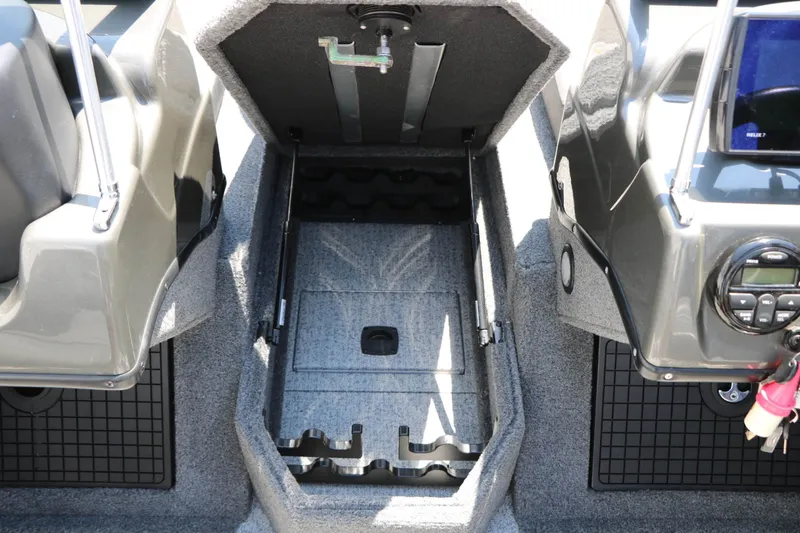 Slide: The Image of The image shows the interior of a 2020 Tracker Targa V 19 Combo boat. There's an open storage compartment between two seats. - 39