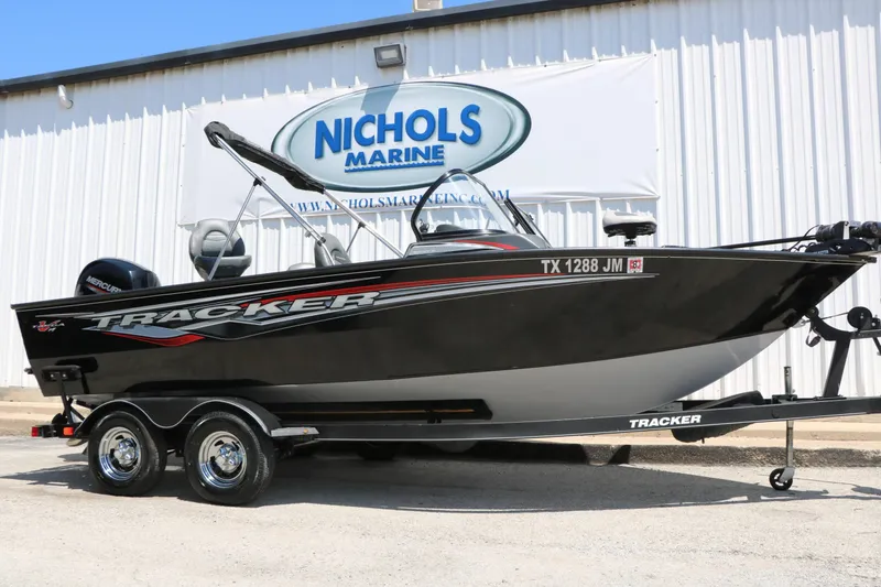 The Image of A black 2020 Tracker Targa V 19 Combo boat on a trailer in front of a building. - 1