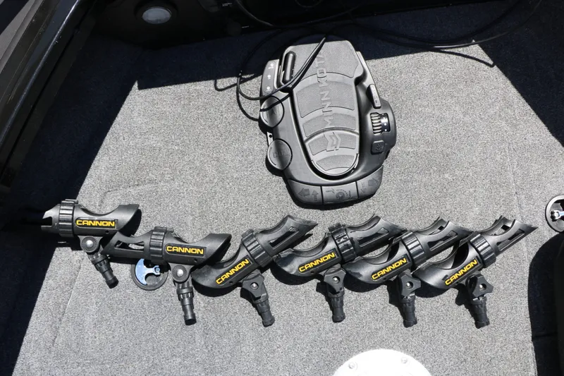 Slide: The Image of A set of six fishing rod holders and an electronic device on a gray carpeted floor. - 36