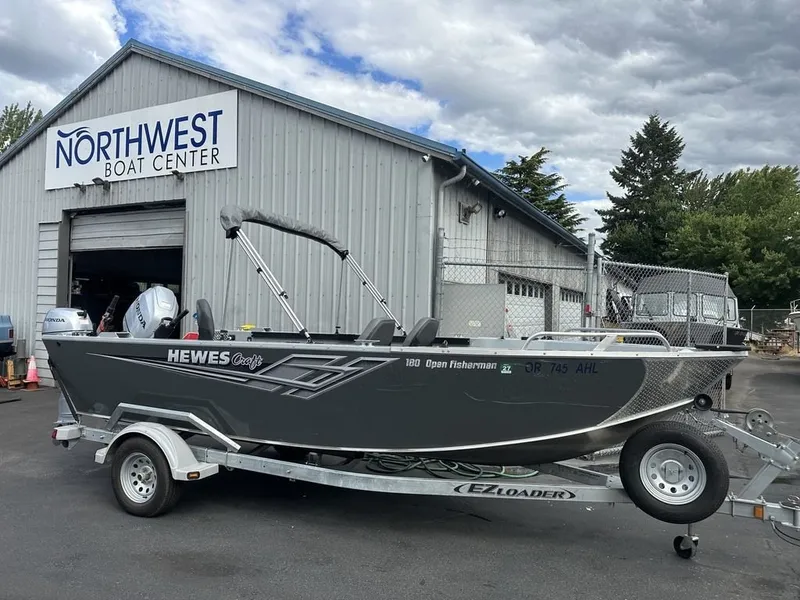 The Image of A gray 2021 Hewescraft Open Fisherman 180 OF boat on a trailer outside a boat center. - 0