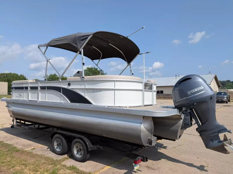 Slide: The Image of A 2019 Bennington 23 SSRXP pontoon boat with a Yamaha outboard motor on a trailer. - 2
