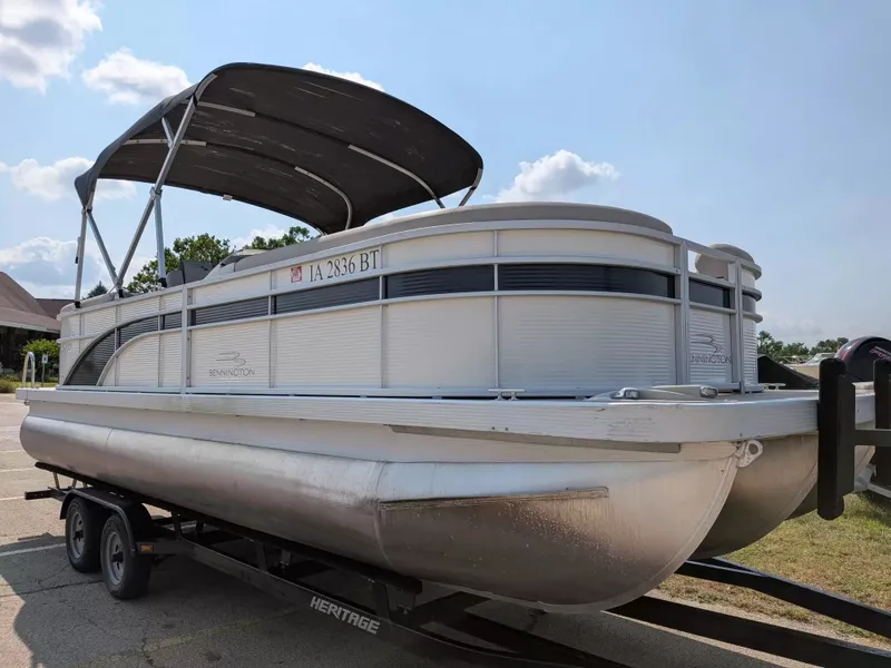 Slide: The Image of A 2019 Bennington 23 SSRXP pontoon boat on a trailer, featuring a black sunshade. - 7