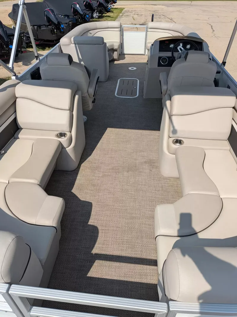 Slide: The Image of The image shows the interior of a 2019 Bennington 23 SSRXP pontoon boat with beige seating. - 13
