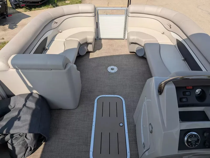 Slide: The Image of The image shows the interior of a 2019 Bennington 23 SSRXP pontoon boat with beige seating. - 16