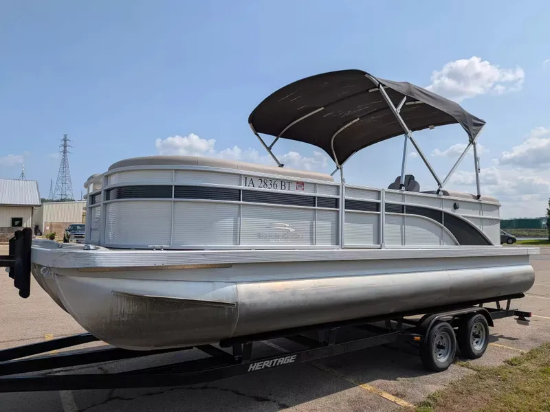 Slide: The Image of A 2019 Bennington 23 SSRXP pontoon boat on a trailer, featuring a gray canopy. - 4