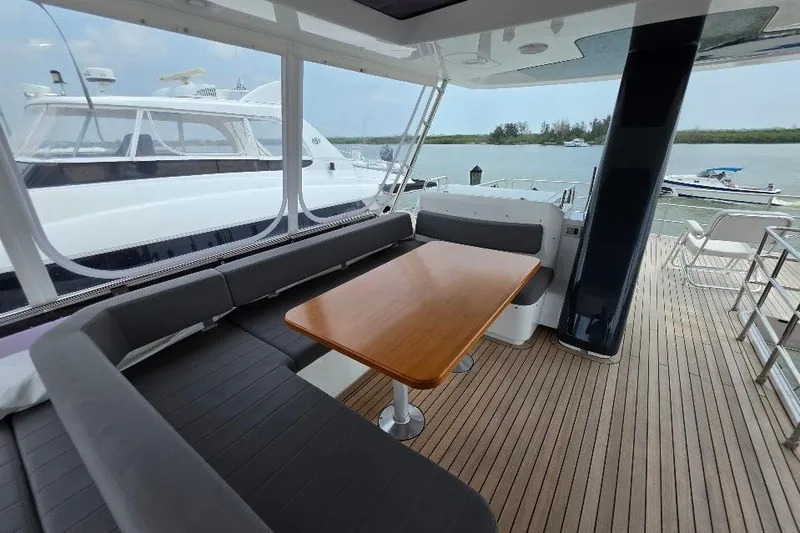 Slide: The Image of Luxurious 2024 Sirena 58 Flybridge yacht with elegant seating and wooden table on deck. - 43