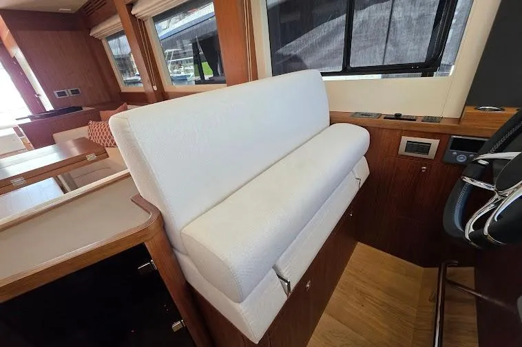 Slide: The Image of Interior of 2024 Sirena 58 Flybridge MY yacht with white seating and wooden accents. - 90