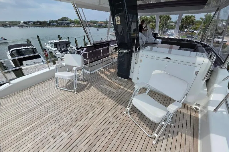Slide: The Image of Flybridge deck of 2024 Sirena 58 Flybridge MY yacht with seating and scenic marina view. - 40