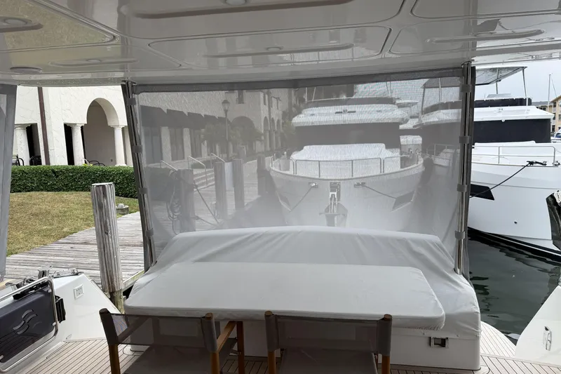 Slide: The Image of 2024 Sirena 58 Flybridge MY yacht with covered seating area at marina dock. - 11