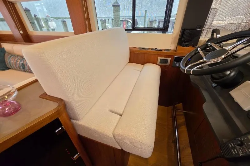 Slide: The Image of Interior helm seating of 2024 Sirena 58 Flybridge MY yacht, featuring a plush white bench. - 80