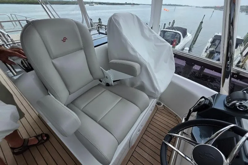 Slide: The Image of Captain's chair on 2024 Sirena 58 Flybridge MY yacht, overlooking marina. - 54