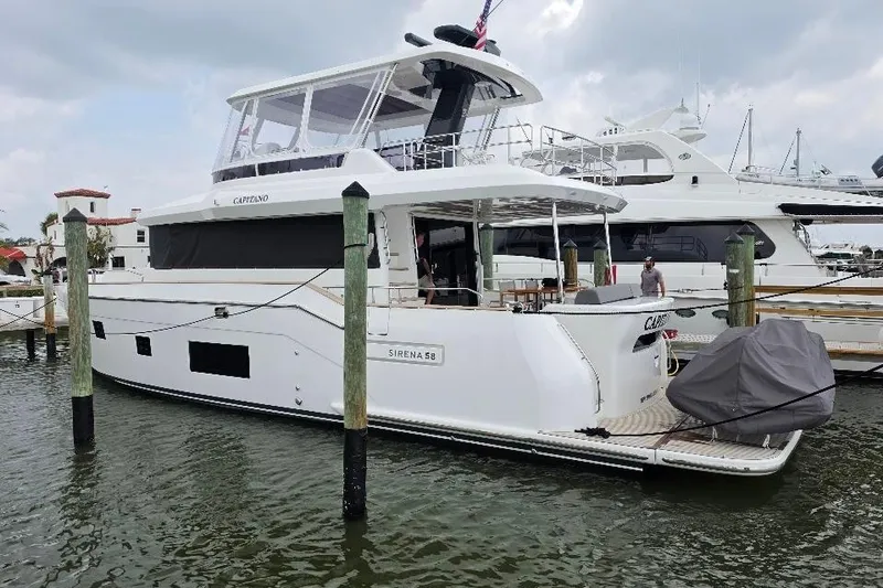 Slide: The Image of 2024 Sirena 58 Flybridge MY yacht docked at marina, featuring sleek design and spacious deck. - 2