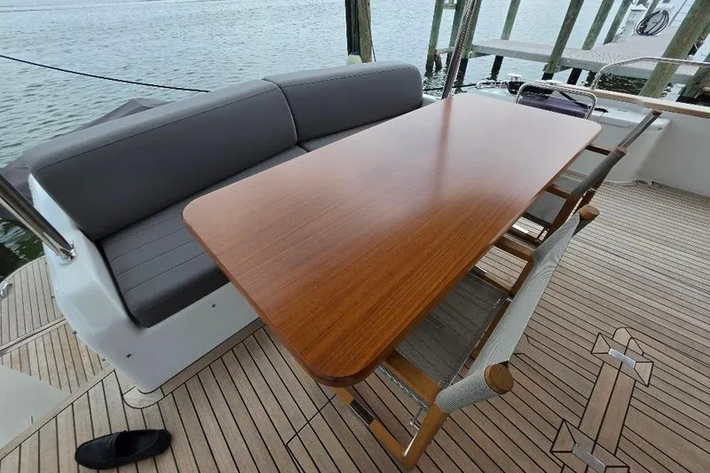 Slide: The Image of Elegant outdoor seating on 2024 Sirena 58 Flybridge MY yacht, featuring a wooden table and cushioned bench. - 15