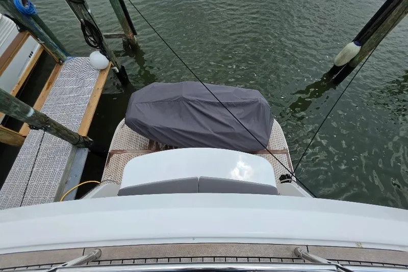 Slide: The Image of 2024 Sirena 58 Flybridge MY yacht stern view at dock with covered equipment. - 49