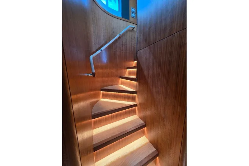 Slide: The Image of Elegant wooden staircase with ambient lighting on the 2024 Sirena 58 Flybridge MY yacht. - 96