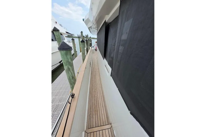 Slide: The Image of 2024 Sirena 58 Flybridge MY yacht docked, showcasing sleek side deck and modern design. - 21