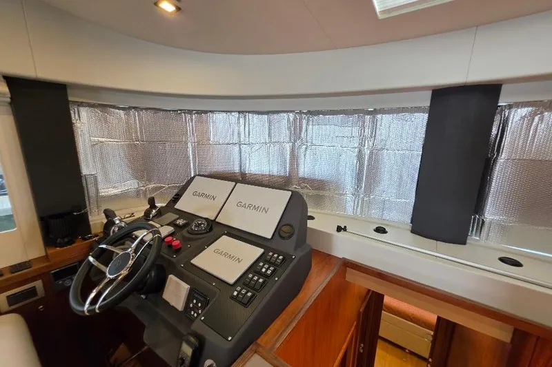 Slide: The Image of 2024 Sirena 58 Flybridge MY helm with Garmin navigation displays and protective window covers. - 83