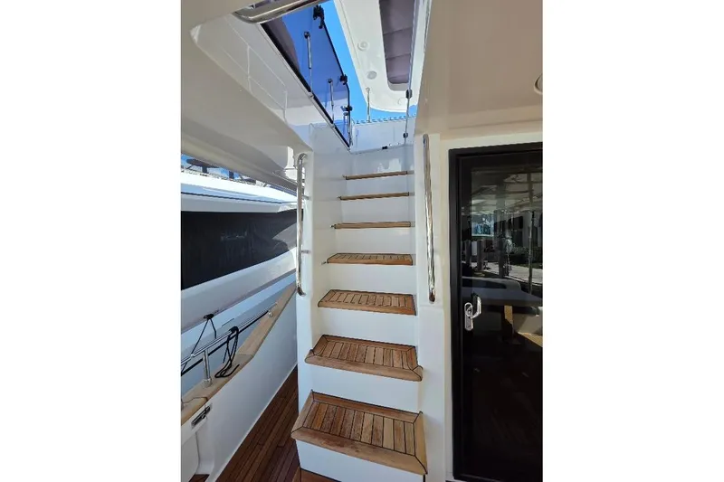 Slide: The Image of Staircase on 2024 Sirena 58 Flybridge MY yacht, featuring sleek design and wooden steps. - 26