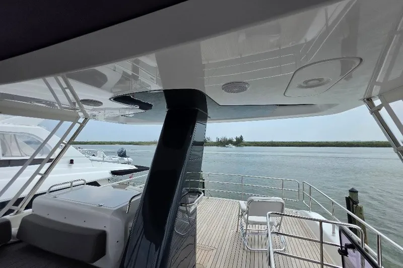 Slide: The Image of Flybridge view of 2024 Sirena 58 yacht, overlooking serene waters and distant shoreline. - 36