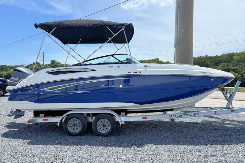 Slide: The Image of 2023 Hurricane SunDeck 2410 OB boat on trailer, blue and white design, with canopy. - 5