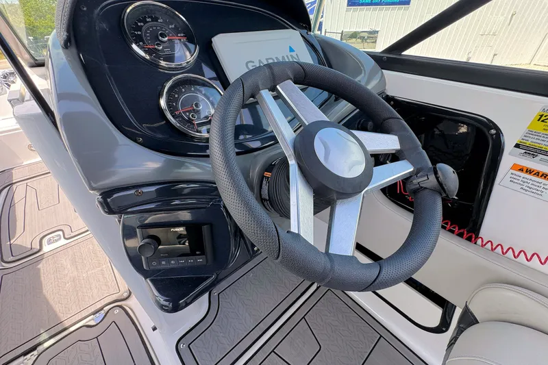 Slide: The Image of 2023 Hurricane SunDeck 2410 OB boat dashboard with Garmin display and steering wheel. - 14