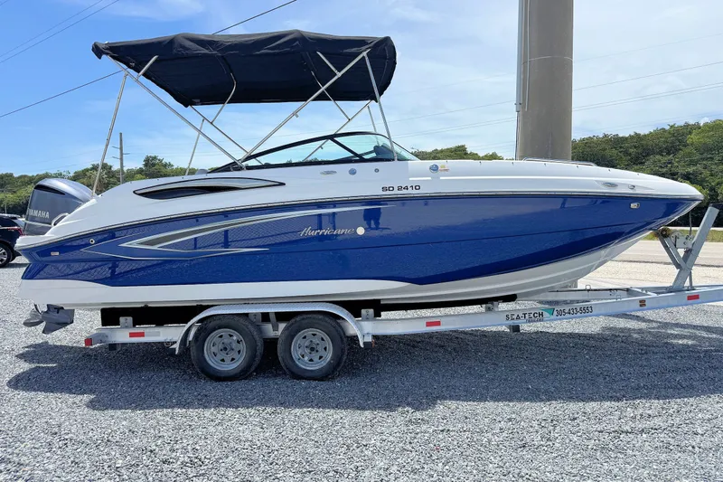 Slide: The Image of 2023 Hurricane SunDeck 2410 OB boat on trailer, blue and white design, with canopy. - 6