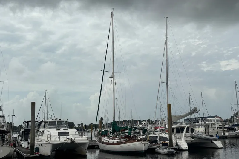 Slide: The Image of Sailboats docked at a marina under cloudy skies, featuring a 1986 Hans Christian 43 T. - 54