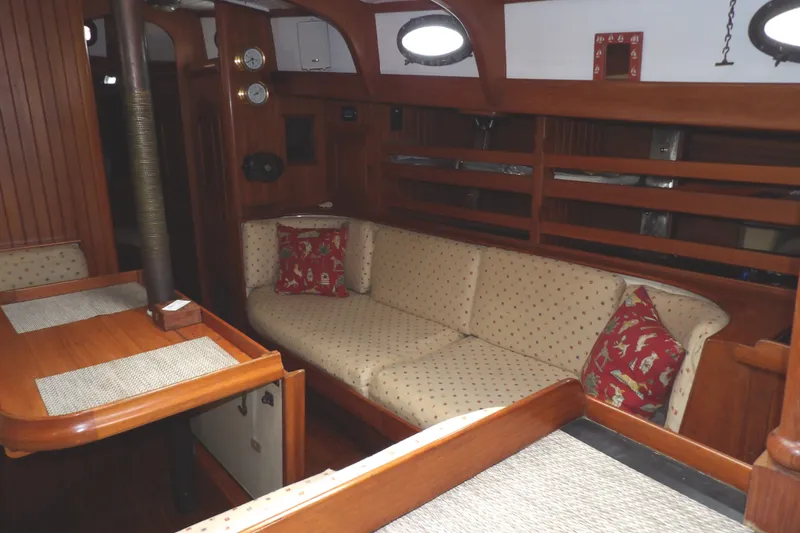Slide: The Image of Interior of 1986 Hans Christian 43 T sailboat with cozy seating and wooden decor. - 43