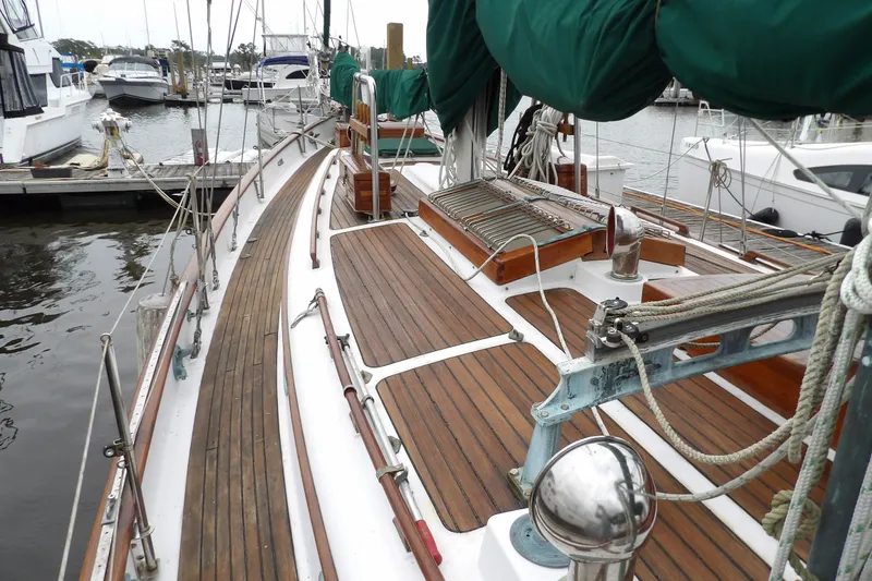 Slide: The Image of 1986 Hans Christian 43 T sailboat with wooden deck and green sail covers at marina. - 19