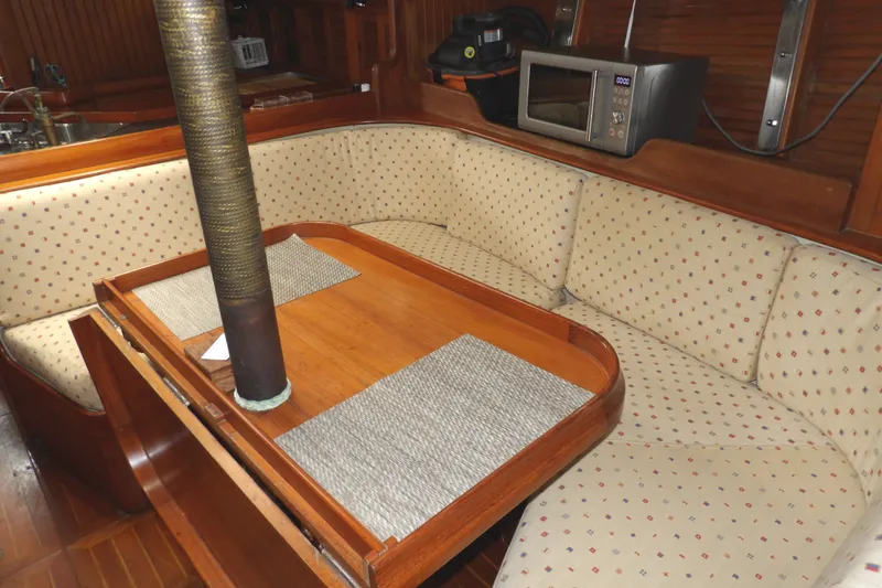 Slide: The Image of Cozy dining area in 1986 Hans Christian 43 T sailboat with cushioned seating and wooden table. - 42