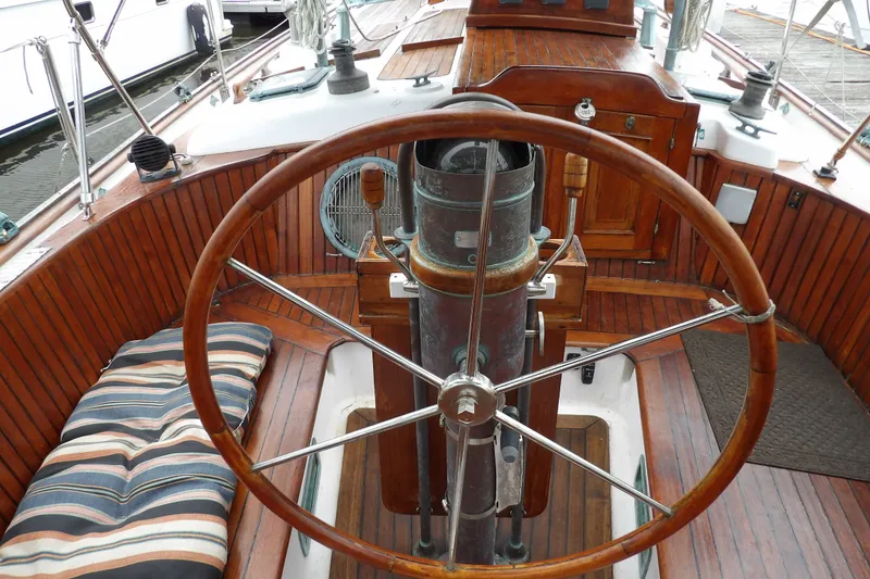 Slide: The Image of 1986 Hans Christian 43 T sailboat cockpit with wooden wheel and striped cushion. - 11