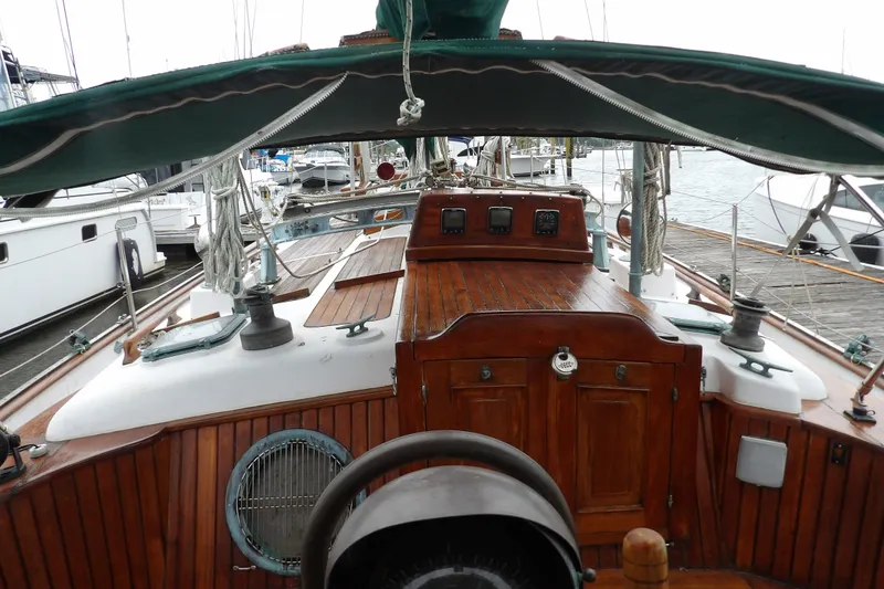 Slide: The Image of 1986 Hans Christian 43 T sailboat with wooden deck and green canopy at marina. - 12