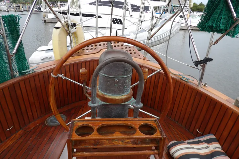 Slide: The Image of Cockpit of 1986 Hans Christian 43 T sailboat with wooden wheel and marina view. - 9