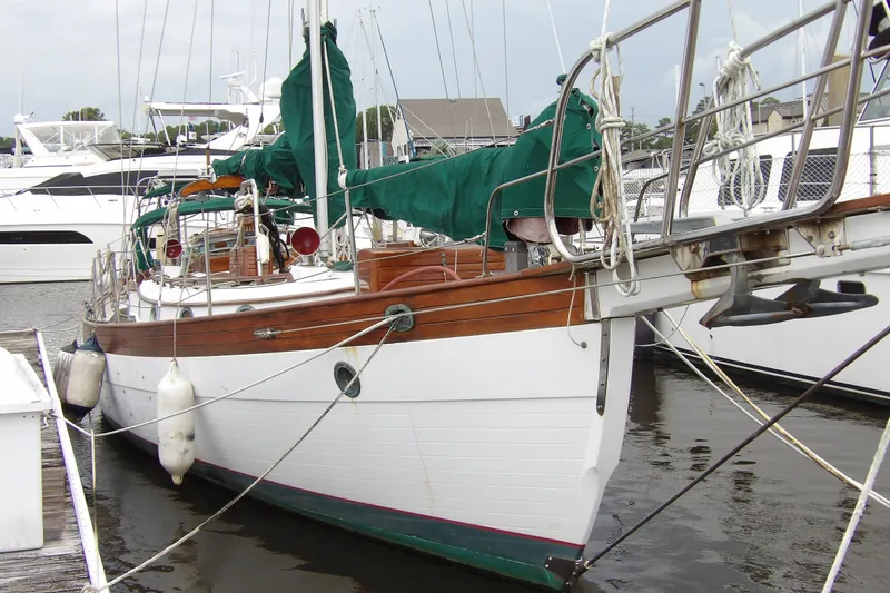 Slide: The Image of 1986 Hans Christian 43 T sailboat docked, featuring classic wooden design and green covers. - 1