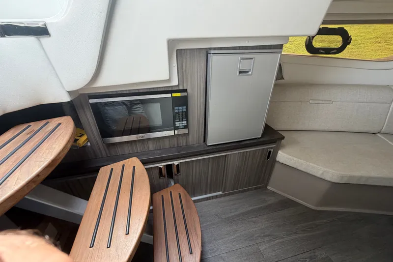 Slide: The Image of Interior of 2021 Sea Ray Sundancer 320 with microwave, fridge, and seating area. - 41