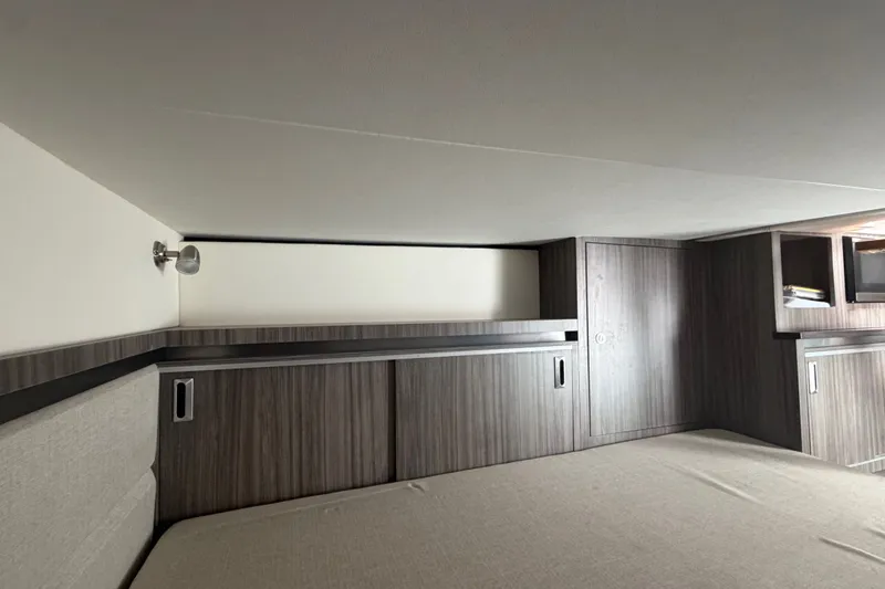 Slide: The Image of Interior cabin of 2021 Sea Ray Sundancer 320 with modern wood paneling and storage. - 30